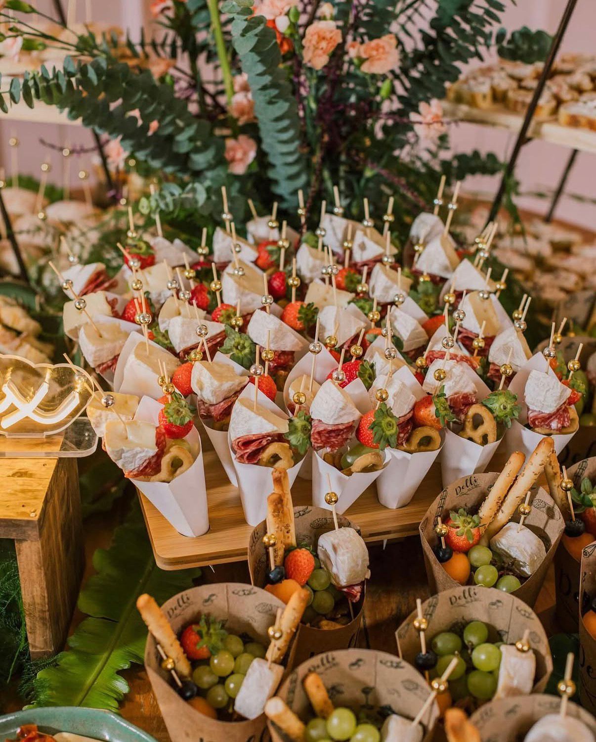 Mesa de frios em pirâmide montada para evento com floral